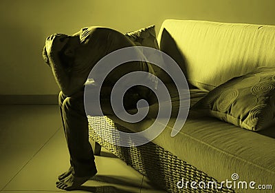 Young desperate sad and frustrated man grieving at home sofa couch suffering depression problem and anxiety crisis crying helpless Stock Photo