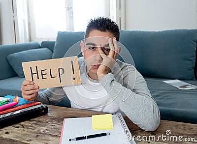 Young desperate student in stress working and studying holding a help sign Stock Photo