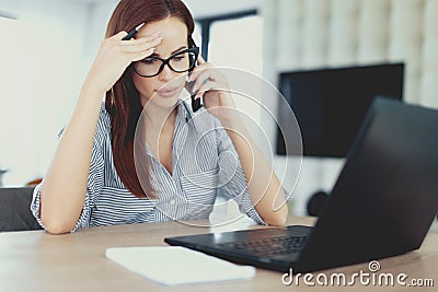 Young diligent energic freelancer woman calling at laptop Stock Photo