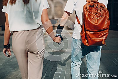 Young disabled man with artificial prosthetic hand walking and holding woman girlfriend hand. Stock Photo