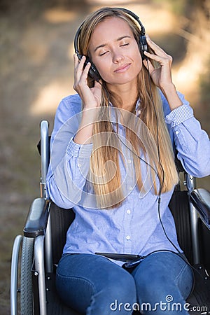 Young disabled woman relaxing with music in nature Stock Photo