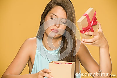 Young disappointed woman opening a present box Stock Photo