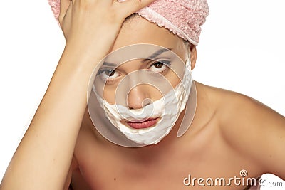 Young disappointed woman posing with shaving foam on her face Stock Photo