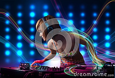 Young Dj girl mixing records with colorful lights Stock Photo