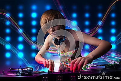 Young Dj girl mixing records with colorful lights Stock Photo