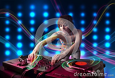 Young Dj girl mixing records with colorful lights Stock Photo