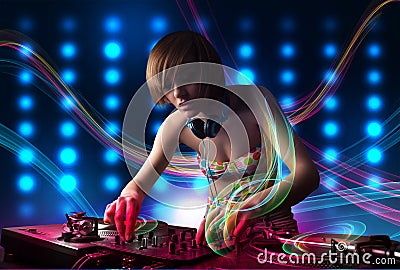 Young Dj girl mixing records with colorful lights Stock Photo