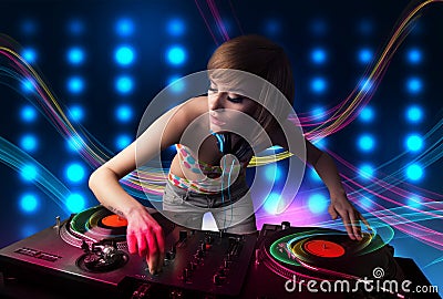 Young Dj girl mixing records with colorful lights Stock Photo