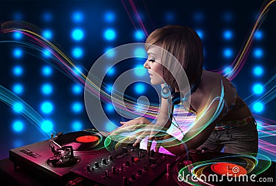 Young Dj girl mixing records with colorful lights Stock Photo