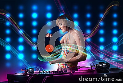 Young Dj girl mixing records with colorful lights Stock Photo