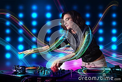 Young Dj girl mixing records with colorful lights Stock Photo