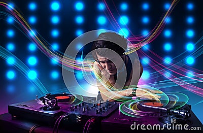 Young Dj mixing records with colorful lights Stock Photo