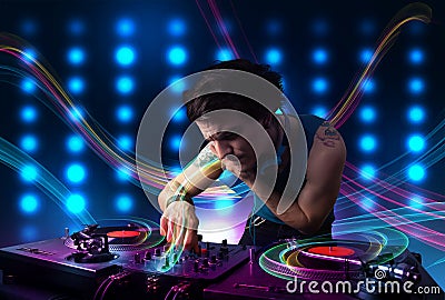 Young Dj mixing records with colorful lights Stock Photo