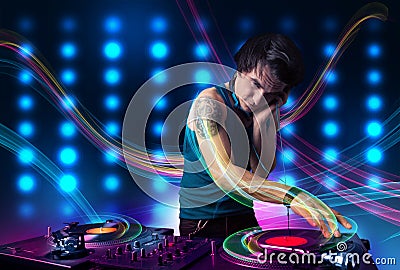 Young Dj mixing records with colorful lights Stock Photo