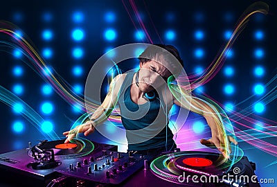 Young Dj mixing records with colorful lights Stock Photo