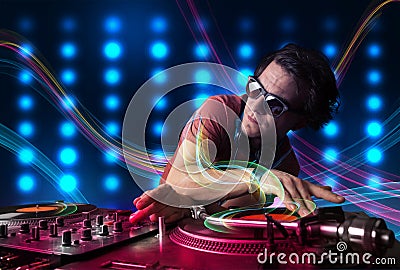 Young Dj mixing records with colorful lights Stock Photo