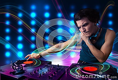 Young Dj mixing records with colorful lights Stock Photo