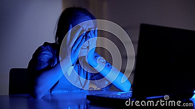 Young doctor crying working on laptop, stress from loss of patient, night shift Stock Photo