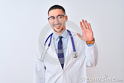 Young doctor man wearing stethoscope over isolated background Waiving saying hello happy and smiling, friendly welcome gesture Stock Photo