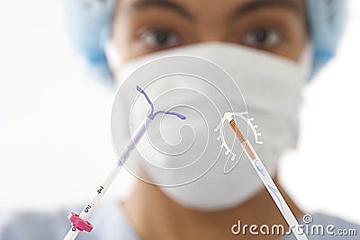 Young doctor showing two type of IUD birth control devices Stock Photo