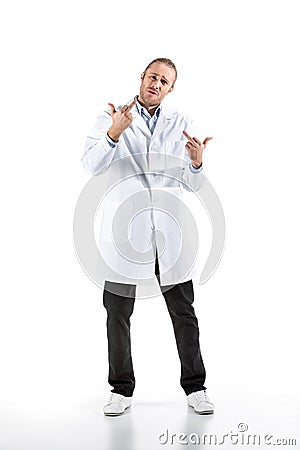 Young doctor in white coat looking at camera and showing middle fingers Stock Photo