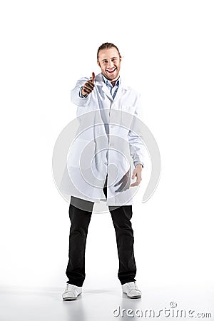 Young doctor in white coat looking at camera with thumb up Stock Photo