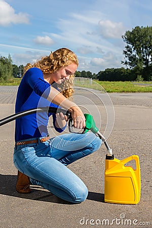 Caucasian woman fueling jerrycan with petrol Stock Photo