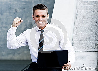 Young Elated Corporate Man With Laptop Stock Photo