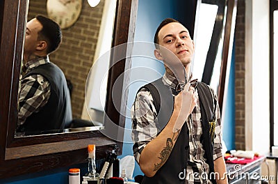 Barber invites to have seat on chair at barbershop Stock Photo