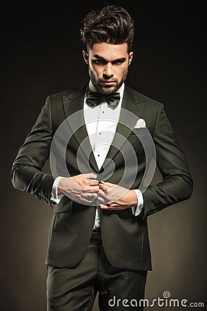 Young elegant business man arranging his tuxedo. Stock Photo