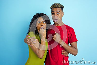 Young emotional african-american man and woman on blue background Stock Photo