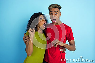 Young emotional african-american man and woman on blue background Stock Photo