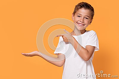 Young emotional little boy on orange studio background. Stock Photo