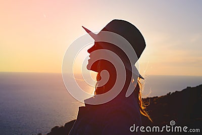 Young emotional woman enjoying sunset on cliff Stock Photo