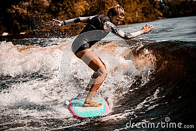 Young energetic woman go in for active water sport with surf style wakeboard Stock Photo