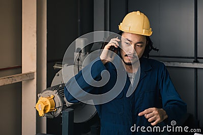 Young engineer talk to his cellphone in factory Stock Photo