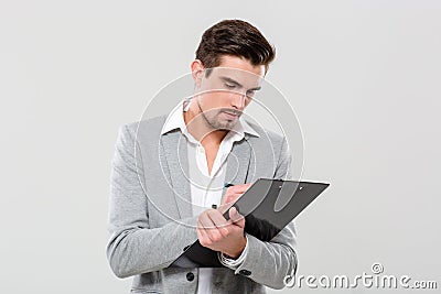 Young enterpreneur writing on clipboard Stock Photo