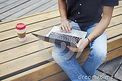 Young entrepreneur working at the park outside on wooden bench.Young entrepreneur working at the park outside on wooden bench. Stock Photo