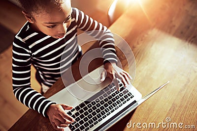 Young ethnic black girl typing on a laptop Stock Photo
