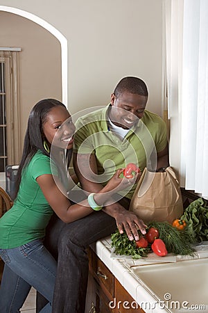 Young ethnic couple on kitchen sorting groceries Stock Photo