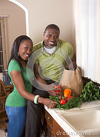 Young ethnic couple on kitchen sorting groceries Stock Photo