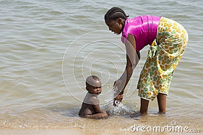 A young ethnic mother washing her baby. Editorial Stock Photo