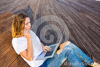 Young European hipster girl skilled freelance social media content writer talking via mobile phone Stock Photo