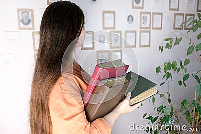 Young european woman with long hair holding old thick photo albums, family archive, concept of genialogy, memory of ancestors, Stock Photo