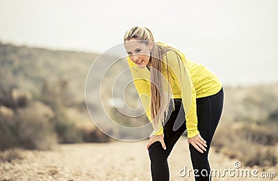 Young exhausted sport woman running outdoors on dirty road breathing Stock Photo