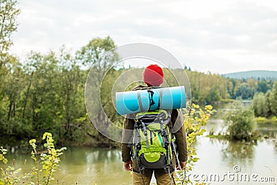 Young explorer standing on the bank of river in front of a fairy tale landscape Stock Photo
