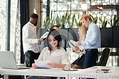 Young exuberant female office worker looking at camera with lovely smile at her workplace in meeting room Stock Photo