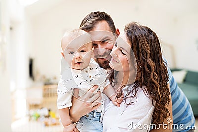 Young family with a baby boy at home, standing and posing for the photo. Stock Photo