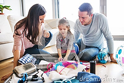 Young family with a child packing for holiday. Stock Photo
