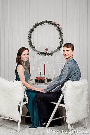 young family couple sitting on the Christmas laid table Stock Photo